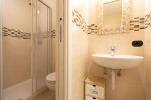 a bathroom with a sink and a shower and a toilet at Pianeta Oro Apartments in Livigno