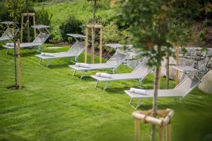 een rij ligstoelen op het gras bij Park Hotel Bellevue in Dobbiaco