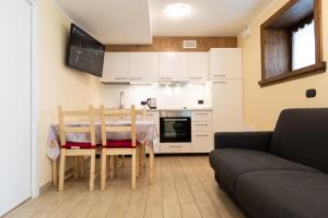 a small kitchen with a table and a couch at Pianeta Oro Apartments in Livigno