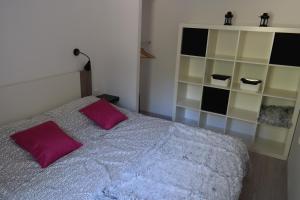 1 dormitorio con cama con almohadas moradas y estante en Apartments Hedona, en Pula