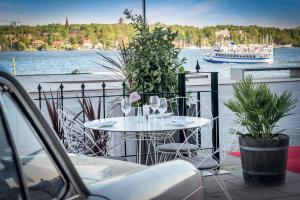 un tavolo bianco con sedie e una barca in acqua di Elite Hotel Marina Tower, Spa & Resort a Stoccolma