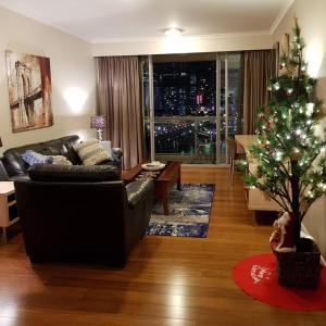 ein Wohnzimmer mit einem Weihnachtsbaum und einer Couch in der Unterkunft Darling Harbour 2 Bedroom Apartment in Sydney