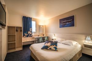 a hotel room with a bed and a desk at Ace Hôtel Toulouse Blagnac in Cornebarrieu