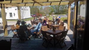 un groupe de personnes assises à des tables sur un patio dans l'établissement The Bluebird Inn at Samlesbury, à Preston