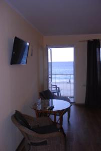 a living room with a table and a view of the ocean at Hotel Palma in Odesa