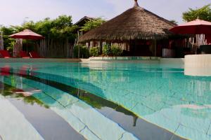 una piscina con capanne e un resort di Pure Plage a Lomé