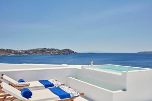 圣爱奥尼斯米科诺斯Katikies Mykonos - The Leading Hotels of the World的一个带椅子的阳台和一个船上游泳池