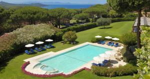 een uitzicht over een zwembad met stoelen en parasols bij Gallia Palace Hotel - Relais & Châteaux in Punta Ala