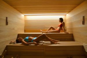 Duas mulheres deitadas numa sauna. em Hotel Ocelle Thermae&Spa (Adults Only) em Sirmione