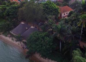 uma vista aérea de uma casa com árvores e água em The Palms Beach Hotel em Entebbe