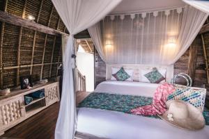 1 dormitorio con 1 cama con columpio en Dream Beach Huts, en Nusa Lembongan