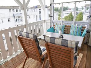 eine Terrasse mit einem Tisch und Stühlen auf dem Balkon in der Unterkunft Seepark Sellin - Apt. 382 in Ostseebad Sellin