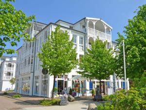 ein großes weißes Gebäude mit Bäumen davor in der Unterkunft Seepark Sellin - Apt. 382 in Ostseebad Sellin