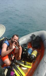 een man in een boot in het water bij Daltons Banana Guesthouse in Banana Island