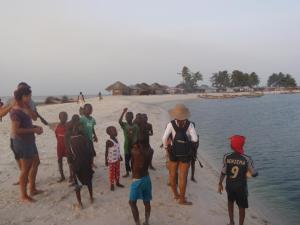 een groep mensen die op een strand staan bij Daltons Banana Guesthouse in Banana Island