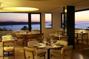 un ristorante con tavoli e sedie con vista sull'oceano di Memmo Baleeira - Design Hotels a Sagres