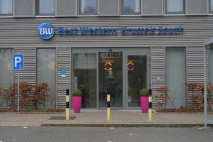 een winkel met een bord aan de voorkant van een gebouw bij BEST WESTERN Hotel Brussels South in Ruisbroek