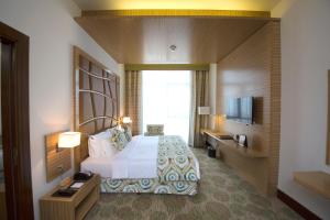 una camera d'albergo con letto e TV di Best Western Plus Pearl Creek a Dubai