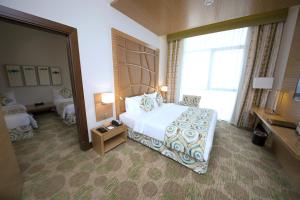 una camera d'albergo con un letto e una grande finestra di Best Western Plus Pearl Creek a Dubai