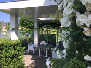 eine Terrasse mit weißen Blumen, einem Tisch und Stühlen in der Unterkunft Villa Envie in Terherne