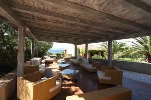 een patio met banken, tafels en stoelen bij Residence Baia Salinedda in San Teodoro