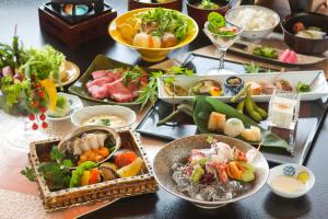 ein Tisch mit vielen Teller Essen drauf in der Unterkunft Kinsuikan in Miyajima