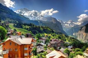 een dorp in de bergen met besneeuwde bergen bij Hotel Edelweiss in Wengen