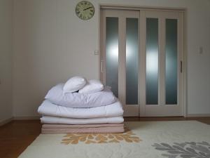 a stack of towels in a room with a clock at La Curación in Naoshima