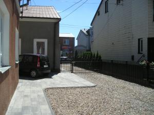 a car parked in a driveway next to a house at Pokoje Centrum U Ani in Augustów