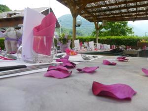 un tavolo con fiori di carta rosa di Auberge de Costaroche ad Albertville