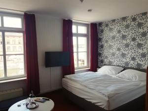 um quarto de hotel com uma cama e duas janelas em Pension Klabautermann em Stralsund