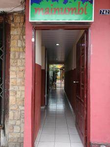 uma entrada para um restaurante com um edifício cor-de-rosa em Mainumbí House em Santa Cruz de la Sierra