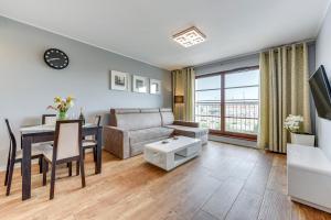 een woonkamer met een bank en een tafel bij GRANO APARTMENTS Gdańsk Nowa Motława SPA & Wellness in Gdańsk