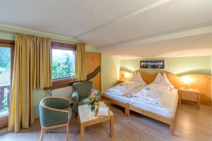 a hotel room with a bed and a table at Hotel Dolomiten in Monguelfo