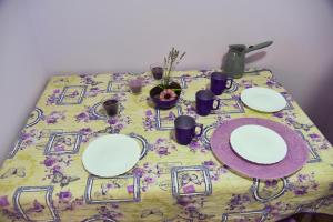 une table avec des plaques blanches sur un tissu de table à fleurs dans l'établissement PRENOĆIŠTE PILOT, à Niš