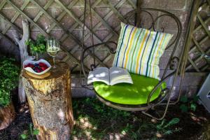 una sedia verde con un libro e un bicchiere di vino di Hotel Gran Fanes a Corvara in Badia