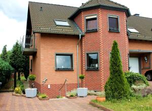 een rood bakstenen huis met ramen en een binnenplaats bij Ferienwohnung " Gecko 2 " in Andernach