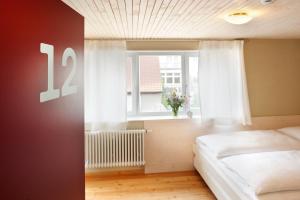 um quarto com uma cama e uma janela em Familienhotel Weimar mit Ferienwohnungen em Veimar