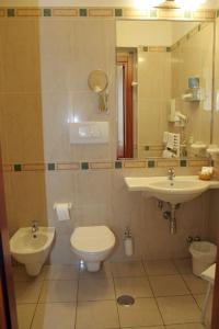 a bathroom with a sink and a toilet and a mirror at Hotel Adria in Bari