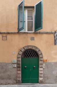 um edifício com uma porta verde e uma janela em Le Camere di Caterina em Lucca