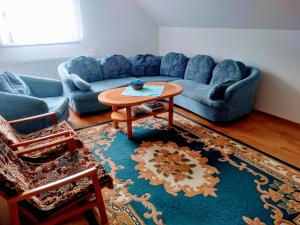 a living room with a blue couch and a table at Apartmán 80 in Oravský Podzámok