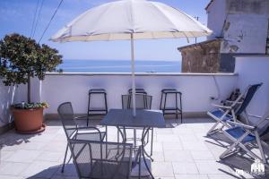 een tafel en stoelen met een parasol op een balkon bij B&B La Muraglia in Bari