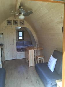 - une chambre avec un canapé et une table dans une petite maison dans l'établissement De Rozephoeve Studio, à Oisterwijk