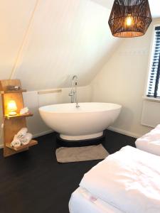 a bathroom with a sink and a bed at De Lindenburg met privé hottub, sunshower, sauna, grote tuin met weidezicht en vrije ligging, 6-persoons in Lievelde