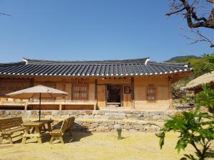 een gebouw met een picknicktafel en een paraplu bij Jukheon Traditional House in Andong