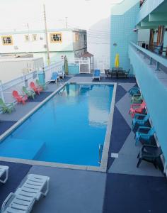 a large swimming pool with lounge chairs and tables at Beachside Resort in Wildwood