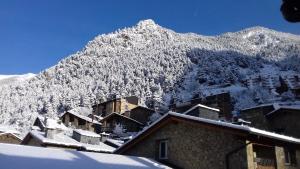 ein schneebedeckter Berg mit Häusern im Vordergrund in der Unterkunft Xalet Besolí in Arinsal