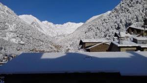 Blick auf eine schneebedeckte Bergkette mit Gebäuden in der Unterkunft Xalet Besolí in Arinsal