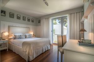 een slaapkamer met een bed, een raam en een bureau bij Cascais Casa Laranja in Cascais