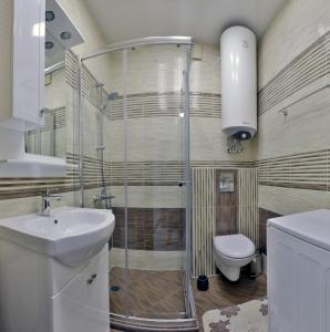 a bathroom with a shower and a toilet and a sink at Apartments Relax 1&2 in Varna City